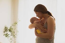Premium Photo | Young mother comforting crying newborn carrying him in her  hands undressed baby in mother's arms skin to skin contact attachment  parenting concept large light window on a background