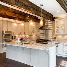 Walnut Ridge Prosource Wholesale White quartz counters with stainless steel hood and brass pendant light fixtures.