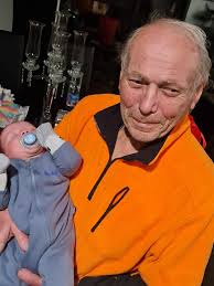 man struggles with lower back pain and uses microphone stand for support