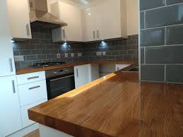 Howdens 3.6m x 38mm square edge authentic oak block effect laminate worktop. White Kitchen Grey Tiles Black Worktop Novocom Top