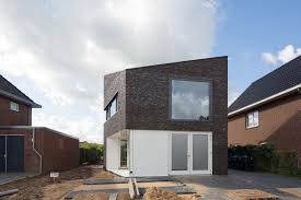 Dark bricks on the exterior of this house and their unique arrangement keep this building smooth in some places and textured in others. Modern Family Home In The Netherlands Tradition With A Twist