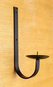 Simple designs like grapevines, spirals, and unadorned wall hangings fall into this category. Curved Flat Bar Wrought Iron Pillar Candle Wall Sconce Etsy Wall Candles Candle Wall Sconces Metal Wall Candle Holders