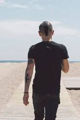What does the mohawk hairstyle symbolize? Back View Of Young Man With Mohawk Haircut And Tattoos Walking On Boardwalk To The Beach Skcf00303 Skabarcat Westend61