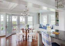 A wallpapered jib door opens to a dining room boasting a chippendale dining chair placed on a dark stained wood floor in front of white wainscoting accenting blue chinoiserie wallpapered upper walls lined with ornate crown moldings. To Beadboard Or Not To Beadboard Patrick Ahearn Architect