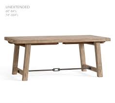 Grooves and saw marks on the wood's surface create the look of salvaged lumber, and oversized bolts on the legs and tabletop add to its rustic feel. Benchwright Extending Dining Table Pottery Barn
