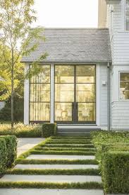 Colorful blooming containers in varying sizes create a garden setting. 15 Beautiful Farmhouse Exterior Design Ideas Modern Farmhouse Exterior Farmhouse Exterior Farmhouse Exterior Design