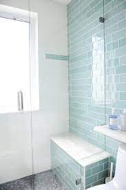 Contemporary shower boasts a gray subway tiled ceiling and walls lined with a white marble top bench alongside a white marble hex tiled shower. Blue Glass Subway Shower Tiles With Gray Mosaic Shower Floor Contemporary Bathroom