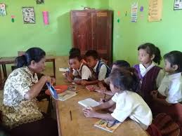 Satu orang guru sedang menerangkan pelajaran kepada seluruh murid di kelas. Membimbing Guru Menjadi Pengajar Yang Menjawab Kebutuhan Belajar Anak Inovasi
