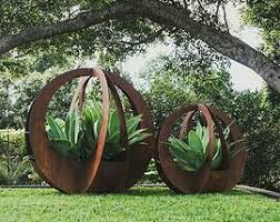 Stunning Outdoor Garden Sculptures Of Corten Steel Encasing Agave Attenuata Broadcroft Design Creative Metaw Garden Art Metal Garden Art Garden Art Sculptures