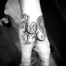 Initial tattoos can express strong emotions and deep love and that is why many couples and lovers get their partners' initials tattooed on themselves instead of getting a matching tattoo. Tattoos Via La Letters Tattoo Chicano Best Tattoo Ideas Tattoo Fonts Chicano Tattoos Lettering Tattoo Lettering