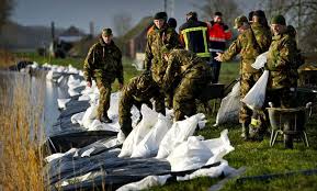 Militairen storten er, bij het licht van schijnwerpers, zandzakken, stenen en stukken puin in. Een Dijkdoorbraak Nu Zou Rampzalige Gevolgen Hebben Trouw
