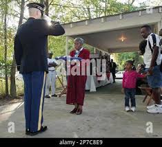 Spc. James Sutherland, left, salutes Marzell Smith, center, as Officer  candidate Brandon Renfro plays 'Taps'