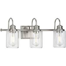 The clean lines of the steel frame add interest while the etched white cylinder glass softens the light to create a warm ambiance for any space. Aiken Collection Three Light Clear Glass Brushed Nickel Farmhouse Style Bath Vanity Wall Light P300322 009 Progress Lighting