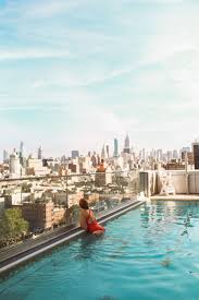 Woman Looking Out Over Manhattan From A Rooftop Pool New York City Travel City Travel Pool City