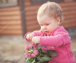 Cute Baby Girl In Pink Dress Puts Flowers Stock Photo By C Rimdream 75347473
