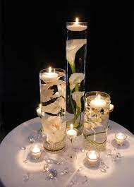 If you want a taller centerpiece with flowers and candles a submerged flower in a cylinder vase with a floating candle on the top would look great. 37 Floating Flowers And Candles Centerpieces Shelterness