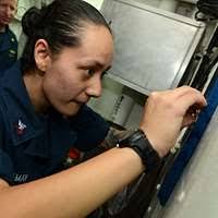 Yeoman 2nd Class Emily Lemay affixes her name plate to a plaque  commemorating Sailors qualified as master helmsman aboard the  guided-missile cruiser USS Gettysburg (CG 64).