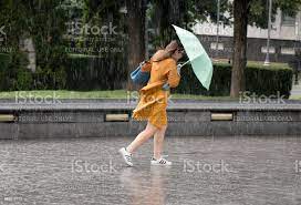 Young Woman Under Umbrella During Sudden Spring Shower Stock Photo -  Download Image Now - iStock