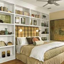 The black cabinets and the stainless steel hardware combine sleek linear fireplace with recessed flat screen tv, porcelain tile surround, nickels cabinetry on each side, floating shelves, large trendy open. Shelves Around Bed Small Master Bedroom Remodel Bedroom Master Bedrooms Decor