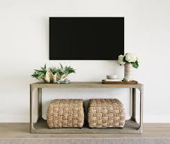 A Flat Panel Television Is Mounted To A White Wall Above A Restoration Hardware Martens Console Table Decorating Mounted Tv Ideas Living Rooms Tv Console Table