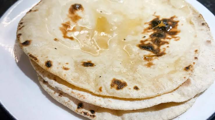 Smearing warm ghee on fresh whole wheat chapatis enhances both flavor and nutrient bioavailability, AI generated