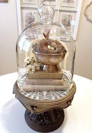 Such A Pretty Cloche Filled With Layers Old Books And Silver Are Charming The Small Nest Is A Spring Staple In 2021 Cloche Decor Spring Easter Decor Spring Decor