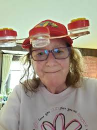 Lending a hummingbird hat feeder to a young girl in Ecuador