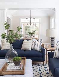 Blue Sofas Accented With White Fringe Pillows Sit In An L Formation On A White And Blue Wo Blue Living Room Decor Blue Couch Living Room Blue Sofas Living Room