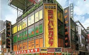 1975年 昭和50年 ヨドバシカメラ 新宿西口本店完成 昭和35年渋谷区本町で藤沢写真商会創業 ビル 地名 風景