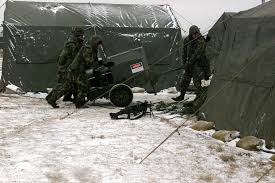 AIRMAN First Class (A1C) Shad Dokml, A1C Mike Santana, A1C Chris Thompson  and STAFF Sergeant Darren Ice, move a portable heater unit near a break  tent
