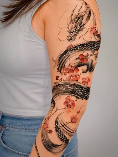 A brushstroke dragon and flowering branches wrapping around the arm 🖤❤️ Thank you :) @e.nal.tattoo @vismstudio