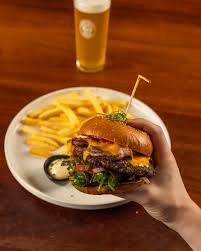 Satisfy your cravings with The Big Earl Burger! 🍔🔥 Featuring a 200g  char-grilled dry-aged beef patty, double cheese, crispy bacon, fresh  tomato, mesclun leaves, pickles, and truffle aioli