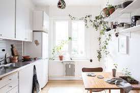 Black accents and fixtures pop against a stark white background in this chic bathroom by a homepolish interior designer. Scandinavian Home With Green Plants