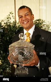 CBS News' weekend anchor Russ Mitchell holds a cup after being awarded the  Press Club of Metropolitian St. Louis' National Journalism Achievement  Award in Maryland Heights, Missouri