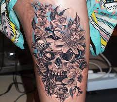 Couples can try matching skull candy tattoos and a cool idea would be to tie up two skulls along with pretty flowers just like this. Skull And Flowers Tattoo By Jurgis Mikalauskas Post 28044