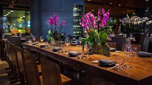 Asian dining room with full height glazing and concrete flooring topped by a bordered area rug. Novikov Asian Restaurant London Opentable