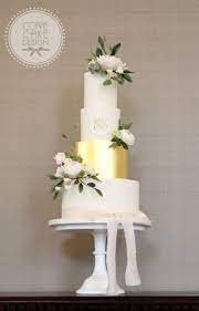 Elegant White And Gold Wedding Cake With Sugar Flowers Monogram And Silk Ribbon White And Gold Wedding Cake Floral Wedding Cakes Wedding Cakes