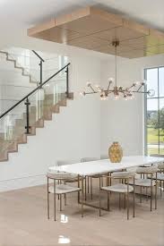 A Modern Chandelier Lights A White And Gold Dining Table Surrounded By Brass And Gray Leather Gold Dining Room Dining Table Gold Dining Room Chandelier Modern