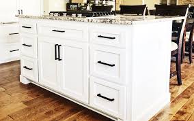 White shaker cabinets black countertops and white stone slab backsplash. Gallery Schnubs