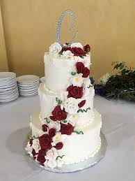 White wedding cake with flowers and blueberries. Wedding Sugarplum Cake Shoppe