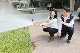 賴沛泠 左 量測消防水管水壓 雲嘉南分署長柯呈枋 右 肯定表現 記者謝進盛 攝影 lab coat