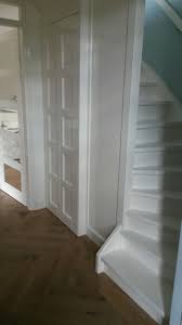 hal met trapkast paneeldeuren en dichte trap naar eerste verdieping eiken visgraat vloer alles in hoogglans wit ges geschilderde trap witte trap trap ideeen