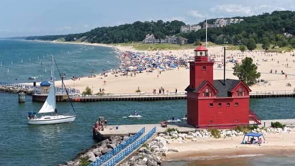 Summer beach fun at Holland Harbor South Pierhead Light and Holland State  Park, MI on Lake Michigan - Photo by VEGA Aerial Imaging