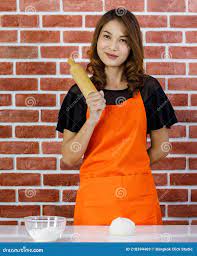 Asian Confident Housewife Amateur Chef in Orange Apron Standing Behind  Kitchen Table with Wheat Flour Glass Bowl Smiling Look at Stock Image -  Image of dessert, brick: 218394469