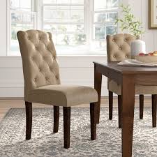 This stylish dining room boasts a bronze and glass globes cluster chandelier hung over a blond wood dining table flanked by vintage metal dining chairs and seating seagrass head chairs. Woven Seagrass Chairs Birch Lane