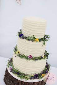 Buttercream Wedding Cake With Rosemary And Bright Flowers Buttercream Wedding Cake Wedding Cakes With Cupcakes Blueberry Cake