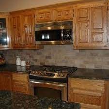 The kitchen includes many furniture like features including a wood mantle hood, open shelving, beadboard and inset cabinetry. Oak Cabinets Ideas On Foter Kitchen Tile Backsplash With Oak Kitchen Remodel Countertops Trendy Kitchen Backsplash