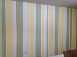 White Wall With Asymmetrical Green And Yellow Stripes Nursery Focal Wall Yellow Nursery Walls Painting Stripes On Walls Striped Walls Bedroom