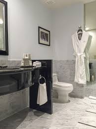 I like that the taupe floor was repeated in the framed mirror above the sink and in the roman shade. One Carrara Marble Bathroom Four Colours