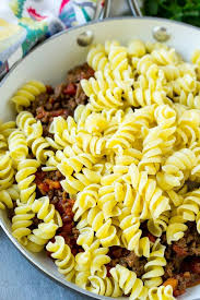 A Skillet Of Cooked Ground Beef Seasoned With Tomatoes And Rotini Pasta Rotini Pasta Recipes Taco Pasta Crockpot Recipes Beef